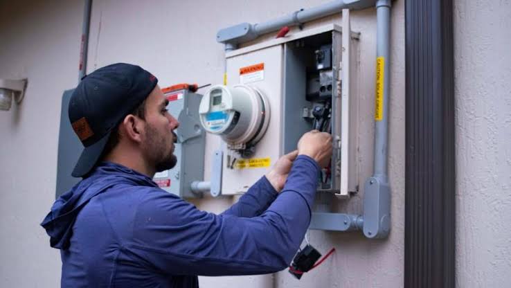 Service technician inspecting an exterior electrical control panel